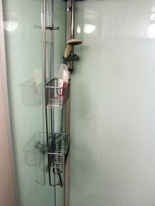 een badkamer met een glazen deur met manden en planken bij Twister 53 in Sparreholm