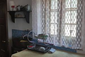 - un comptoir de cuisine avec une fenêtre avec des rideaux et un panier dans l'établissement Šeherezada, à Kosjeric