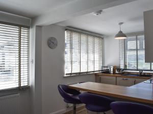 a kitchen with a table and chairs and windows at Old Chapel in Levens