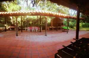 a pavilion with a table and chairs in a forest at Posada Turística Vicenta Aguayo in Yaguarón