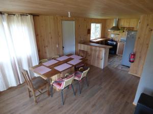a kitchen and dining room with a table and chairs at Cabañas Austral Rivers in Puelo