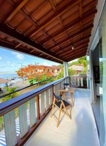 a balcony with a table and a view of the ocean at Pousada Atracadouro Boipeba in Cayru