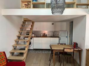 a room with a dining table and a loft bed at Suite Bergame in Caluire-et-Cuire