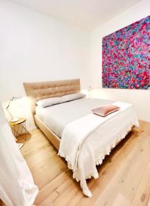 a bedroom with a bed and a painting on the wall at Apartment Suite - Charlize - in the heart of Milan in Milan