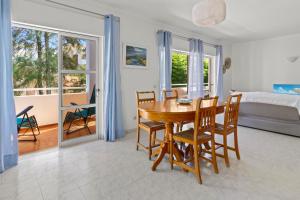 a dining room with a table and chairs and a bedroom at T2 Maralvor in Alvor