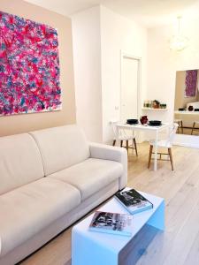 a living room with a white couch and a painting at Apartment Suite - Charlize - in the heart of Milan in Milan