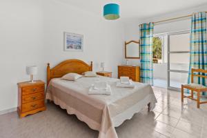 a bedroom with a large bed and a window at T2 Maralvor in Alvor