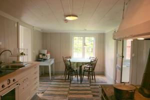 a kitchen with a table and chairs in a room at Brännsjötorp in Målilla