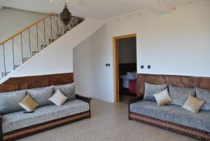 a living room with two couches and a staircase at Ferme Dar Aicha green Bellouta 