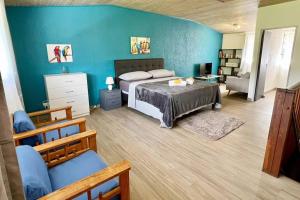 um quarto com uma cama e uma parede azul em HEIPOE LODGE - 6 min airport, Wifi, AC & Parking em Papeete
