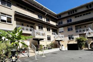 an apartment building with balconies and a parking lot at HEIPOE LODGE - 6 min airport, Wifi, AC & Parking in Papeete