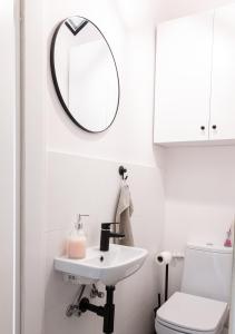 baño con lavabo y espejo en la pared en ClickTheFlat Krucza City Center Apart Rooms, en Varsovia