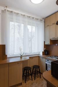 una cocina con dos taburetes frente a una ventana en ClickTheFlat Krucza City Center Apart Rooms, en Varsovia