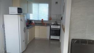 eine Küche mit einem weißen Kühlschrank und einem Herd in der Unterkunft Alquiler Temporario Shanti in Trelew