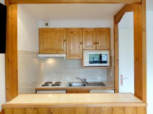 a kitchen with wooden cabinets and a sink at Studio Tignes, 1 pièce, 4 personnes - FR-1-502-504 in Tignes