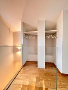 an empty room with glass shelves and wood floors at La Loggia dei Mercanti in Cuneo +11 photos