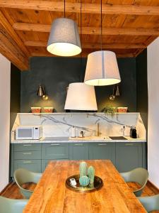 a kitchen with a wooden table and some lights at La Loggia dei Mercanti in Cuneo