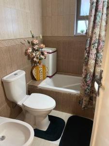 ein Badezimmer mit einem WC, einer Badewanne und einem Waschbecken in der Unterkunft 3 bedroom apartment in Ţāb Kirā‘