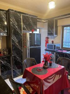 eine Küche mit einem Tisch und einem roten Tischtuch in der Unterkunft 3 bedroom apartment in Ţāb Kirā‘