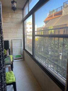 Zimmer mit einem Balkon und einem großen Fenster in der Unterkunft 3 bedroom apartment in Ţāb Kirā‘