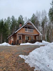 a log cabin in the woods in the snow at Jamali Cabin in Lieksa