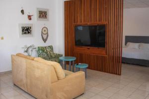 a living room with a couch and a tv and a bed at Hotel & Suites Arges - Centro Chetumal in Chetumal