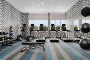 a gym with rows of treadmills and weights at Aloft Katy Mills in Katy