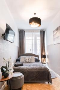 1 dormitorio con 1 cama, TV y mesa en ClickTheFlat Krucza City Center Apart Rooms en Varsovia