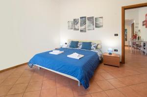 Schlafzimmer mit einem Bett mit blauer Bettwäsche und einem Spiegel in der Unterkunft Casa Viotti Monza in Monza