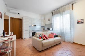 ein Wohnzimmer mit einem Sofa und einer Küche in der Unterkunft Casa Viotti Monza in Monza