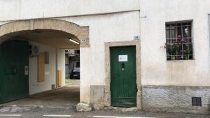ein Gebäude mit einer grünen Tür und einem Fenster in der Unterkunft Antica Corte da Edi in San Daniele del Friuli