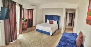 a hotel room with a bed and a television at Acuarium Suite Resort in Santo Domingo