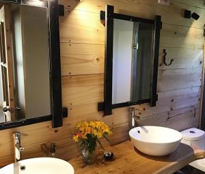 a bathroom with two sinks and two mirrors at Piedra Nevada in Malalcahuello