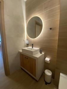 La salle de bains est pourvue d'un lavabo, d'un miroir et de toilettes. dans l'établissement Aristi boutique stonehouse with attic, à Aristi