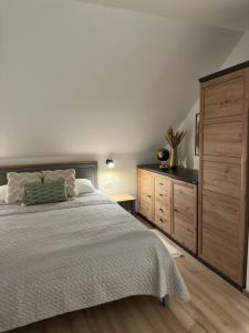 a bedroom with a large bed and a wooden dresser at Apartments Green Linden in Lipovača