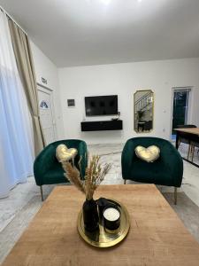 a living room with two green chairs and a table at Apartments Green Linden in Lipovača +38 photos