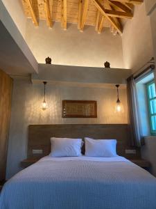 - une chambre avec un lit et 2 oreillers blancs dans l'établissement Aristi boutique stonehouse with attic, à Aristi