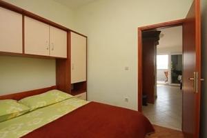 a bedroom with a bed and a door to a hallway at Apartments Pašman in Banj