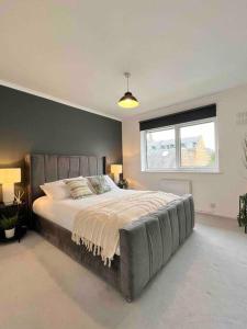 a bedroom with a large bed and a window at BEAUTIFUL WINDSOR 2 BED, PERFECT LOCATION, 5 Mins Walk to Centre, Private Gated Parking, Legoland, Ascot in Windsor