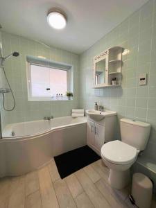 a bathroom with a toilet and a tub and a sink at BEAUTIFUL WINDSOR 2 BED, PERFECT LOCATION, 5 Mins Walk to Centre, Private Gated Parking, Legoland, Ascot in Windsor