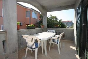 a white table and chairs on a patio at Apartments Pašman in Banj