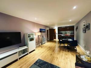 a living room with a television and a dining room at Spacious Luxury Waterfront Apartment in Ipswich