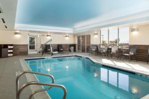 una piscina en un hotel con sillas y mesas en Fairfield Inn & Suites by Marriott Sacramento Folsom en Folsom