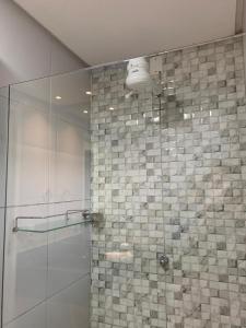 een badkamer met een douche en een glazen deur bij CASA COM PISCINA GARANHUNS in Garanhuns