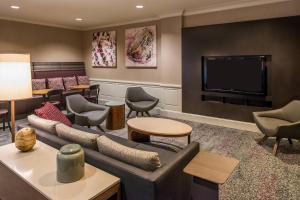 a living room with a couch and a flat screen tv at Courtyard Clemson in Clemson