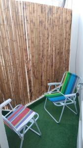2 sillas sentadas junto a una valla de madera en departamento en almagro, 2 huéspedes en Buenos Aires