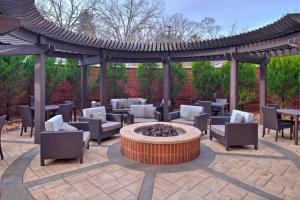 a patio with a fire pit and chairs and a pergola at Courtyard Clemson in Clemson