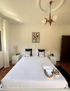 uma grande cama branca num quarto com tecto em VILA GUIA in Valdreu em Braga