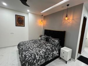 a bedroom with a bed with a black and white comforter at Chic Noir 1 Bedroom Apartment Gulberg in Lahore