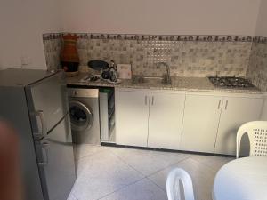 a kitchen with a refrigerator and a sink and a washing machine at Appartement near to AirPort 262 avenue el khalij in Marrakesh